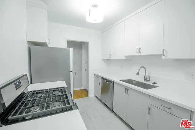 a kitchen with granite countertop a sink stove and cabinets