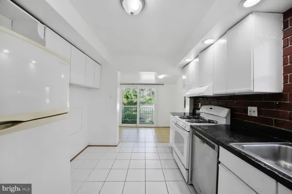 a kitchen with a sink a stove and cabinets