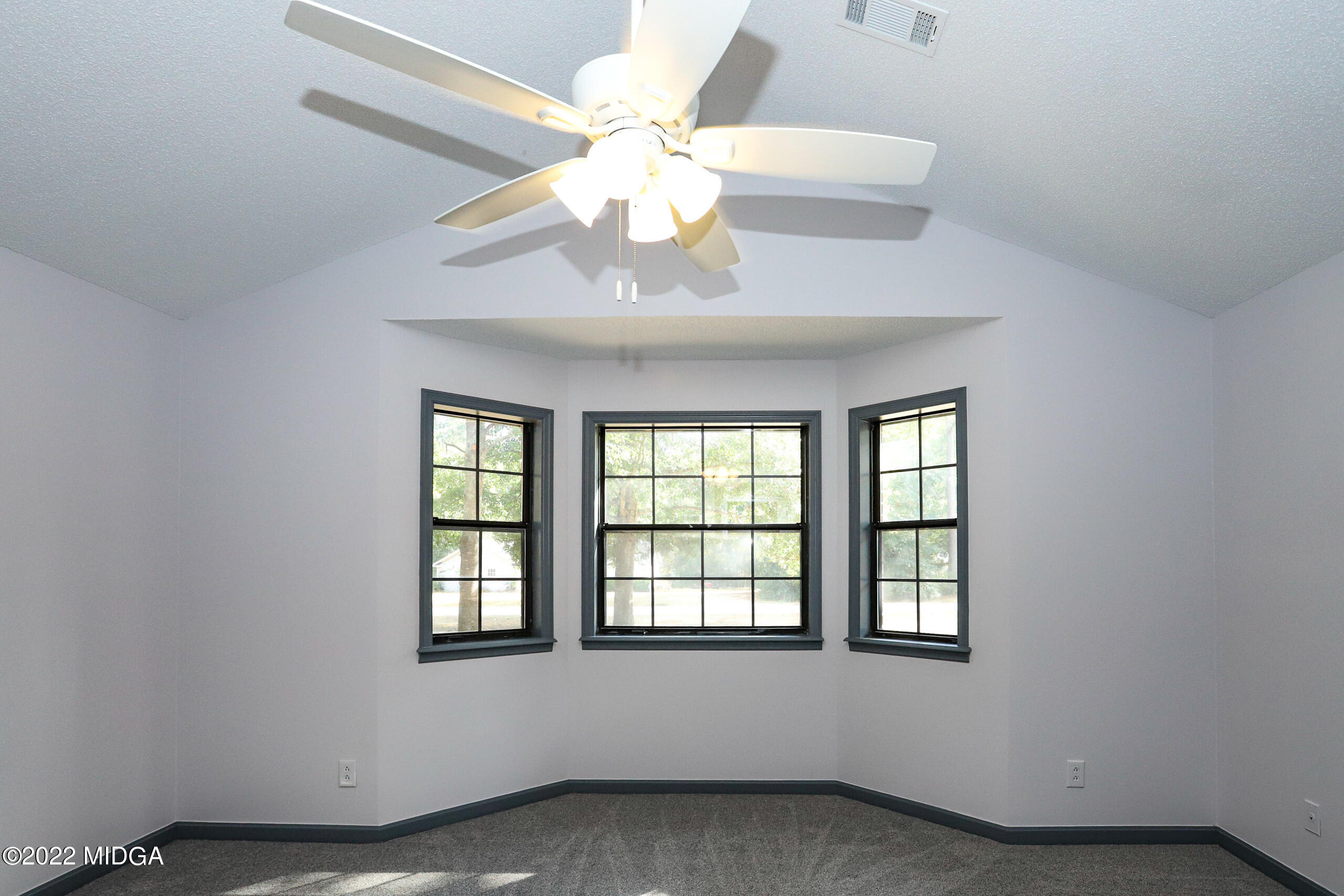 107 Ridge Circle Macon, GA 31216 - Photo 75 of 80 an empty room with a chandelier fan and windows