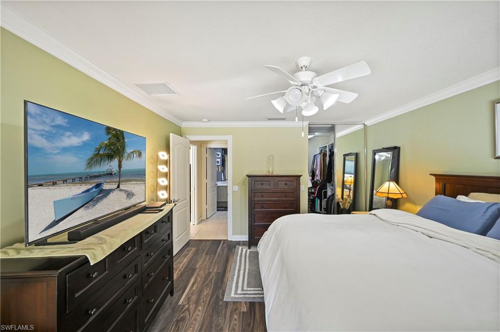 4910 Kingston Way Naples, FL 34119 - Photo 13 of 24 Bedroom featuring crown molding, dark wood-type flooring, ceiling fan, and a spacious closet