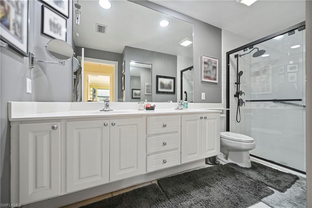 4910 Kingston Way Naples, FL 34119 - Photo 14 of 24 Full bathroom with double vanity, a shower stall, tile patterned flooring, and recessed lighting