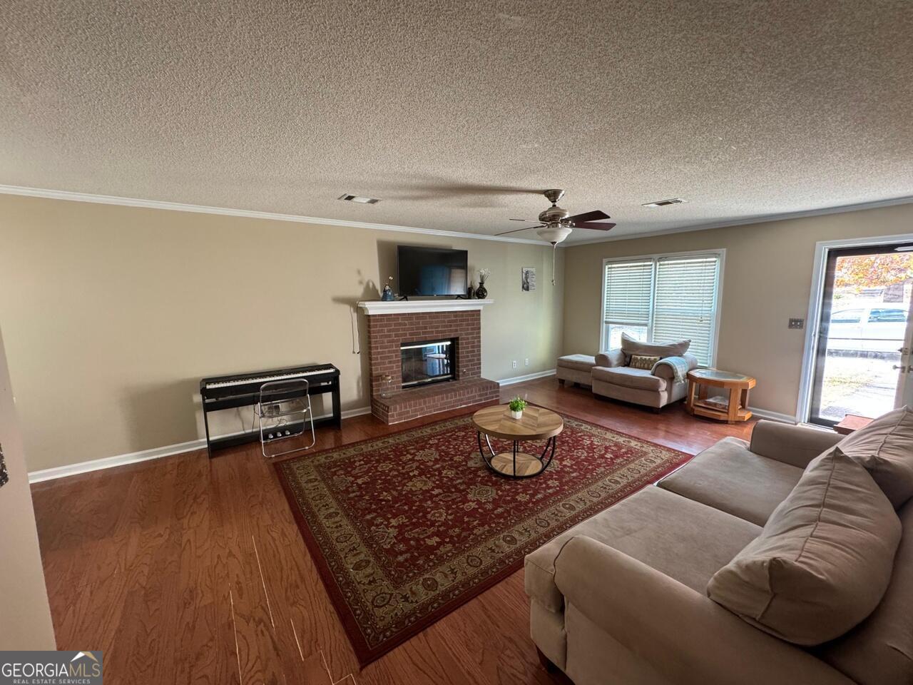 113 Manor Row Macon, GA 31210 - Photo 2 of 19 a living room with furniture a fireplace and a flat screen tv