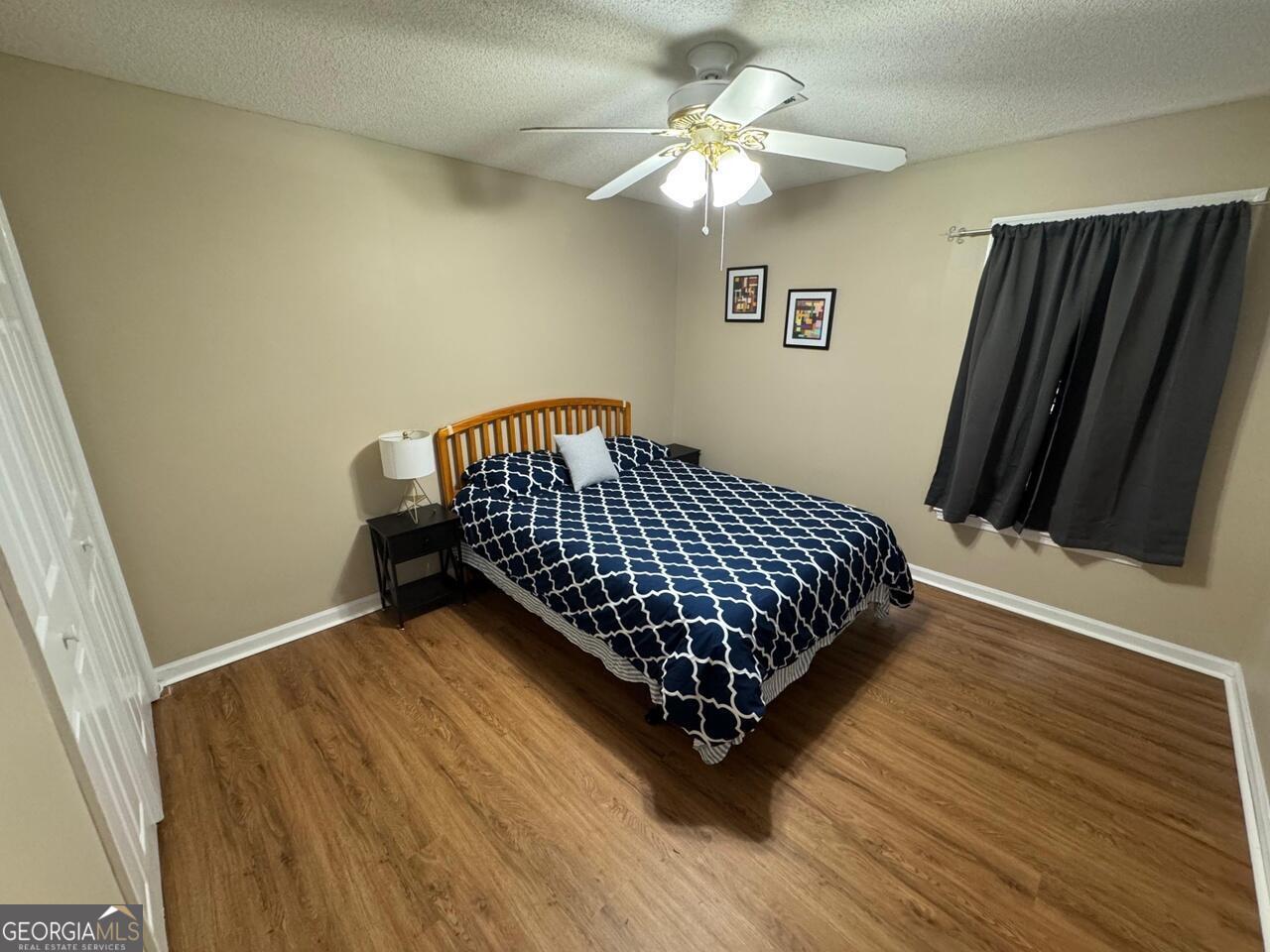 113 Manor Row Macon, GA 31210 - Photo 8 of 19 a bedroom with wooden floor and a ceiling fan