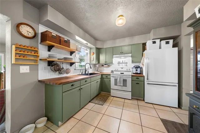 a kitchen with a sink a refrigerator and cabinets