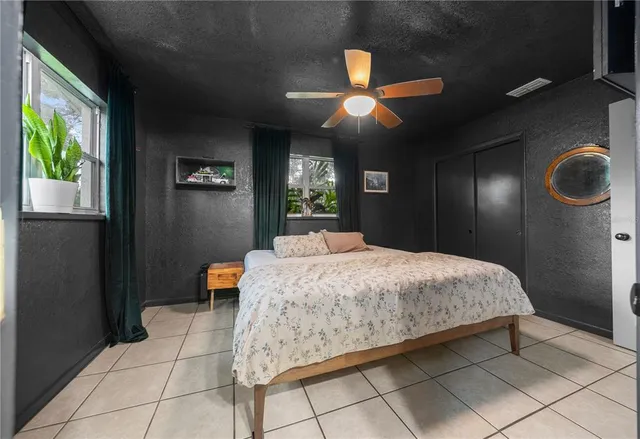 a bedroom with a bed mirror and window