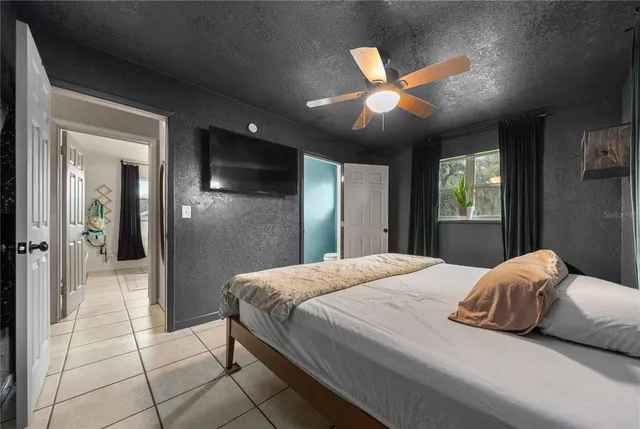 a bedroom with a large bed and a chandelier