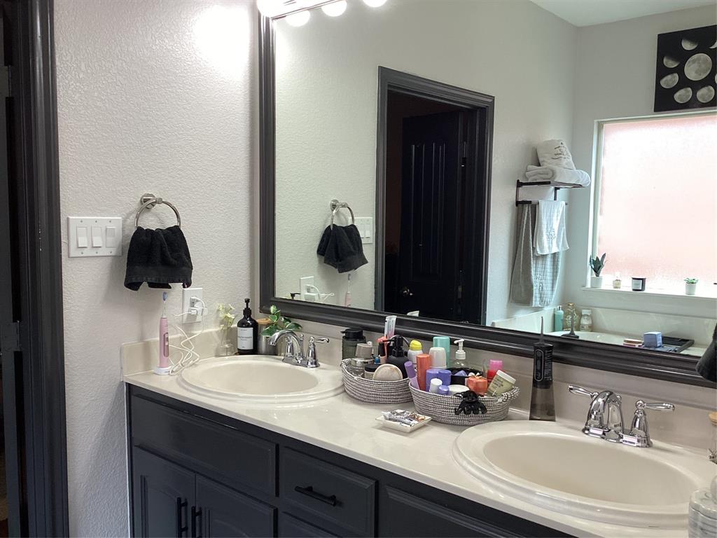 10320 Point Lobos Trail Fort Worth, TX 76177 - Photo 16 of 33 Double vanity with integrated sinks, light-toned countertops, and dark cabinetry