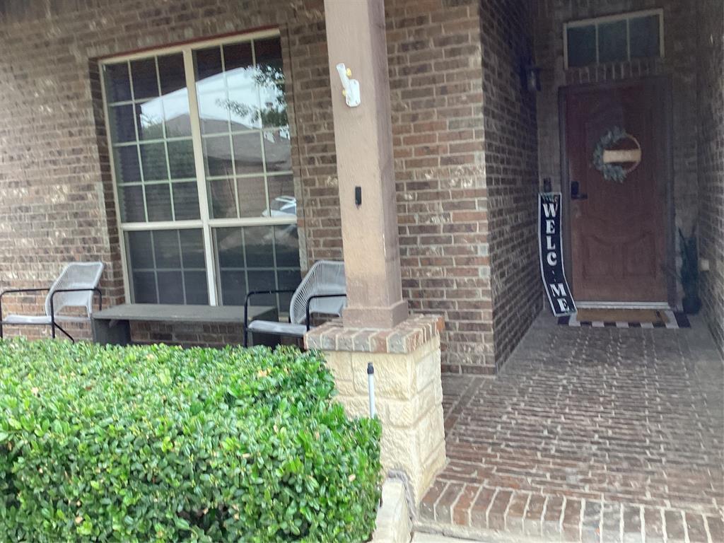 10320 Point Lobos Trail Fort Worth, TX 76177 - Photo 2 of 33 Brick facade with a prominent front entry, featuring a dark wood door with an arched top panel