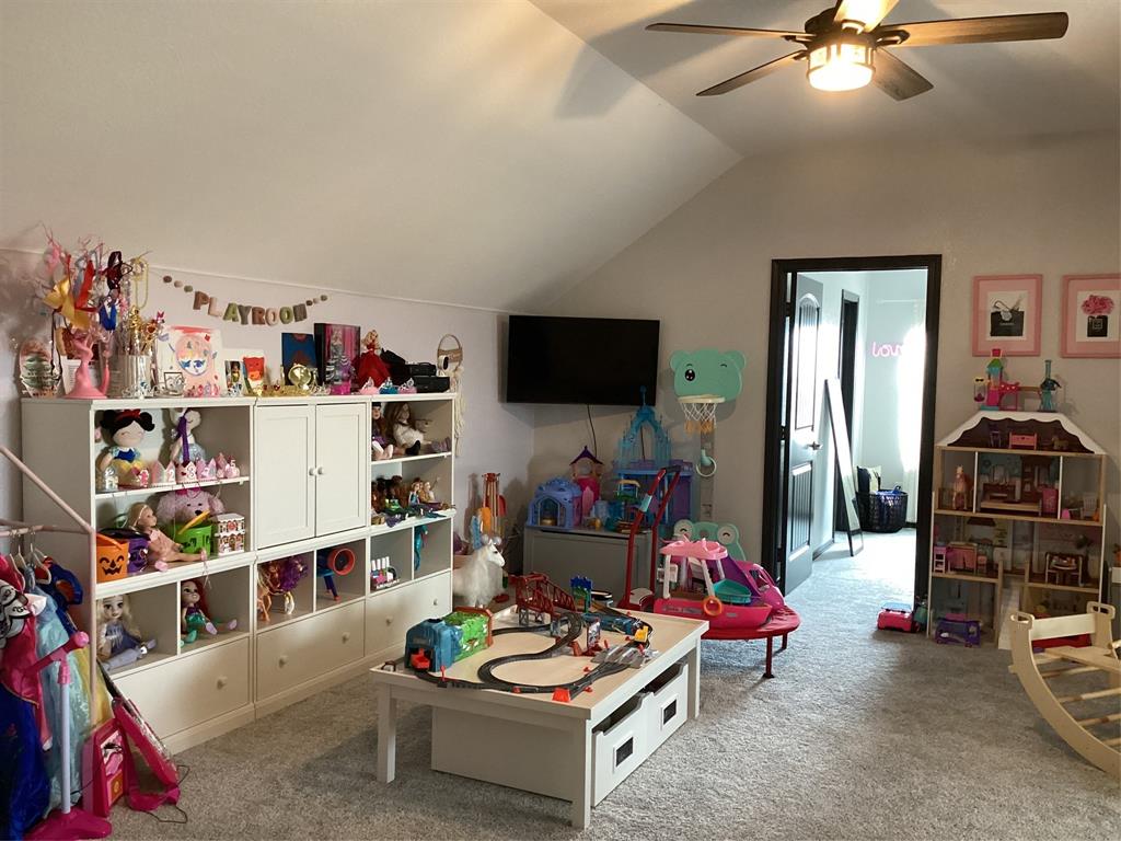10320 Point Lobos Trail Fort Worth, TX 76177 - Photo 24 of 33 Carpeted room with a vaulted ceiling, ceiling fan with integrated lighting, and a dark-trimmed doorway
