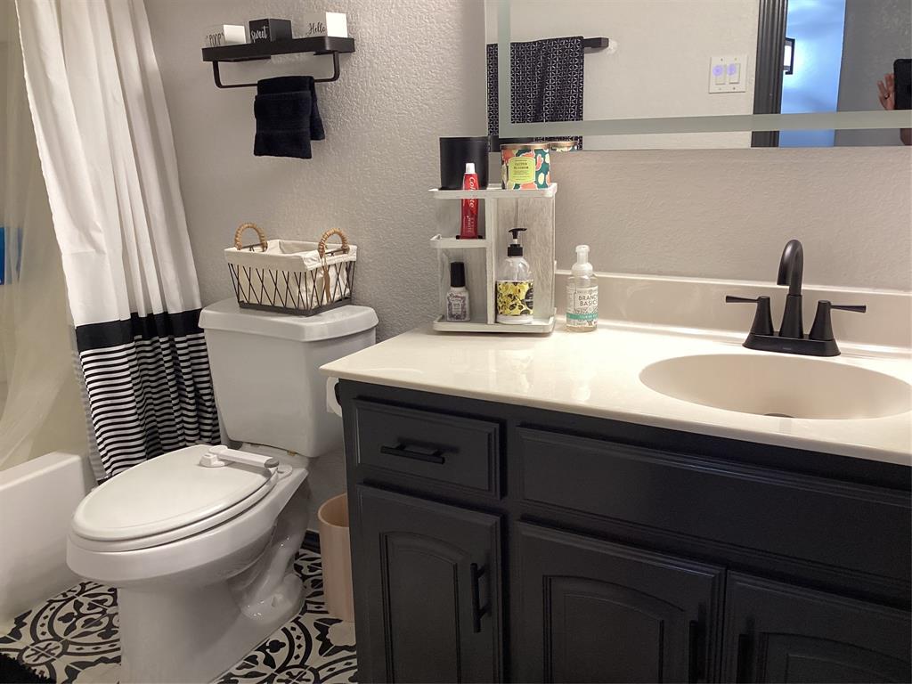 10320 Point Lobos Trail Fort Worth, TX 76177 - Photo 26 of 33 Bathroom featuring a dark vanity with a light countertop, a built-in sink, and a black faucet