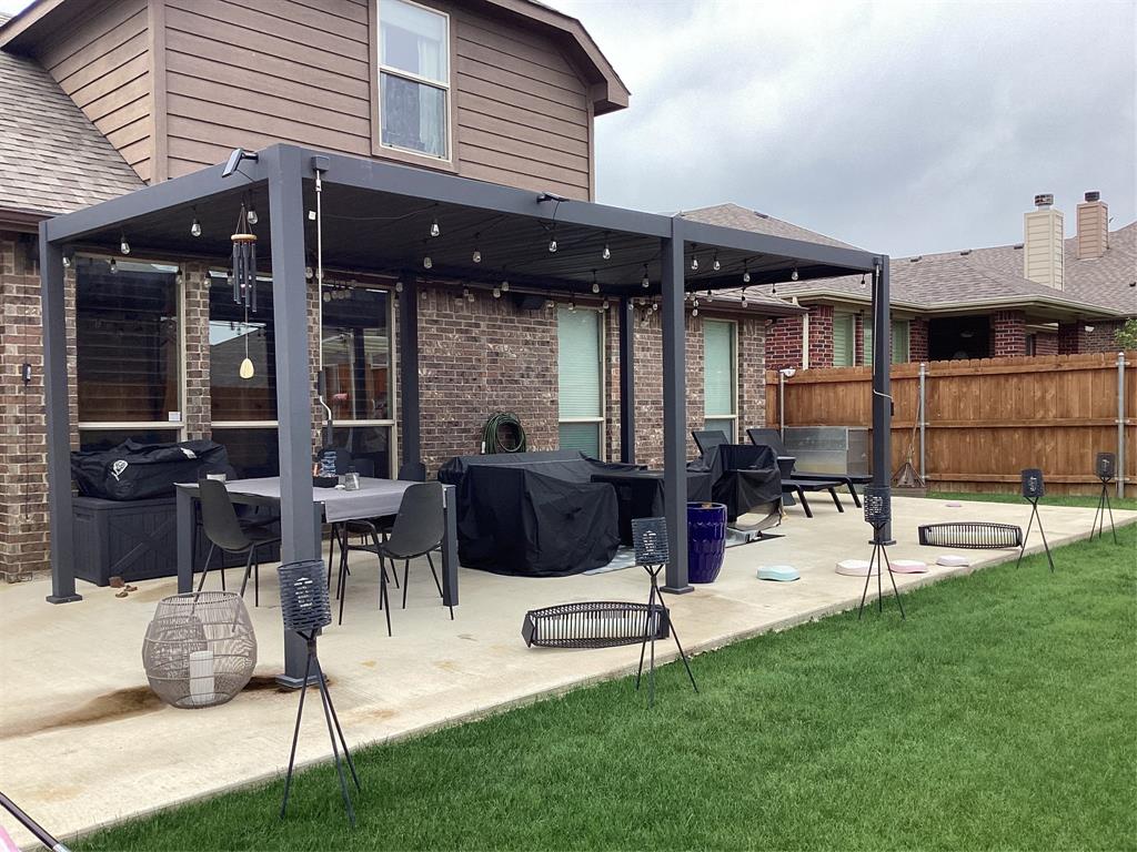 10320 Point Lobos Trail Fort Worth, TX 76177 - Photo 32 of 33 Spacious backyard patio featuring a dark-framed pergola, exposed aggregate concrete, and a surrounding privacy fence
