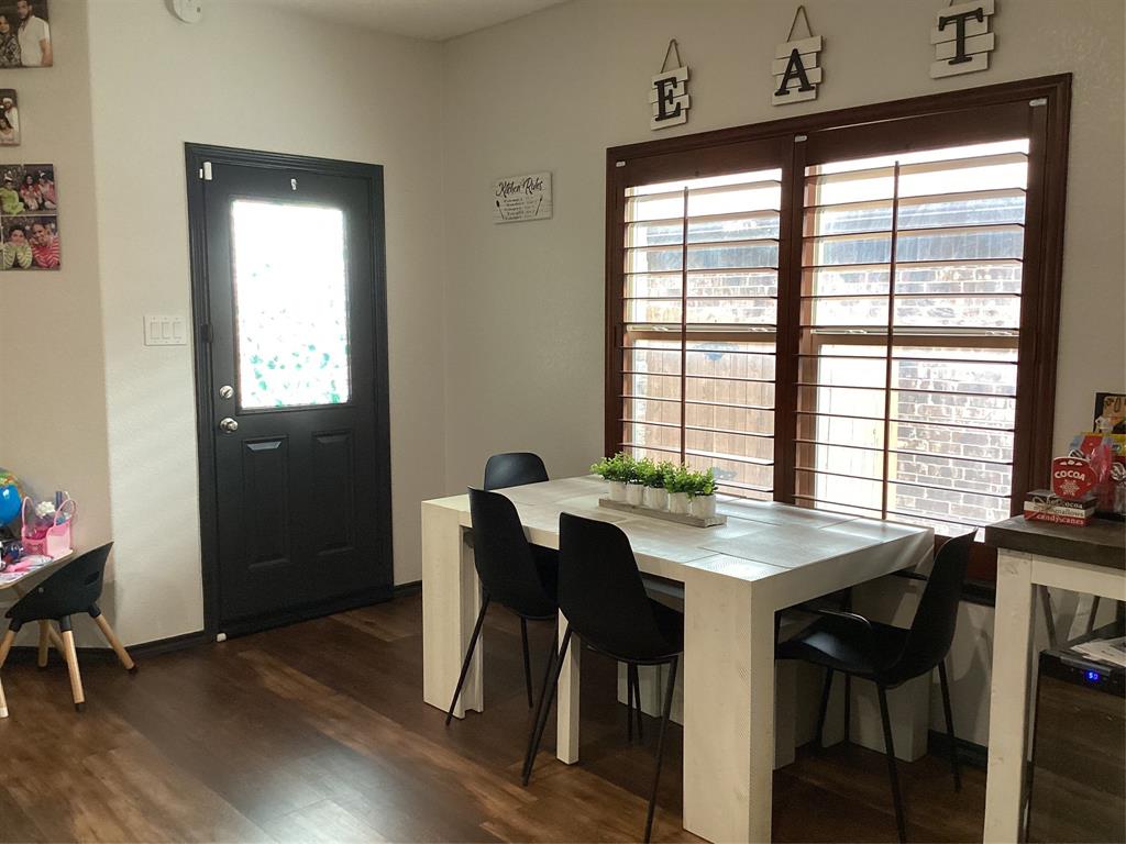 10320 Point Lobos Trail Fort Worth, TX 76177 - Photo 9 of 33 Dining area featuring rich wood-finish flooring, a white dining table, and dark framed windows with integrated blinds