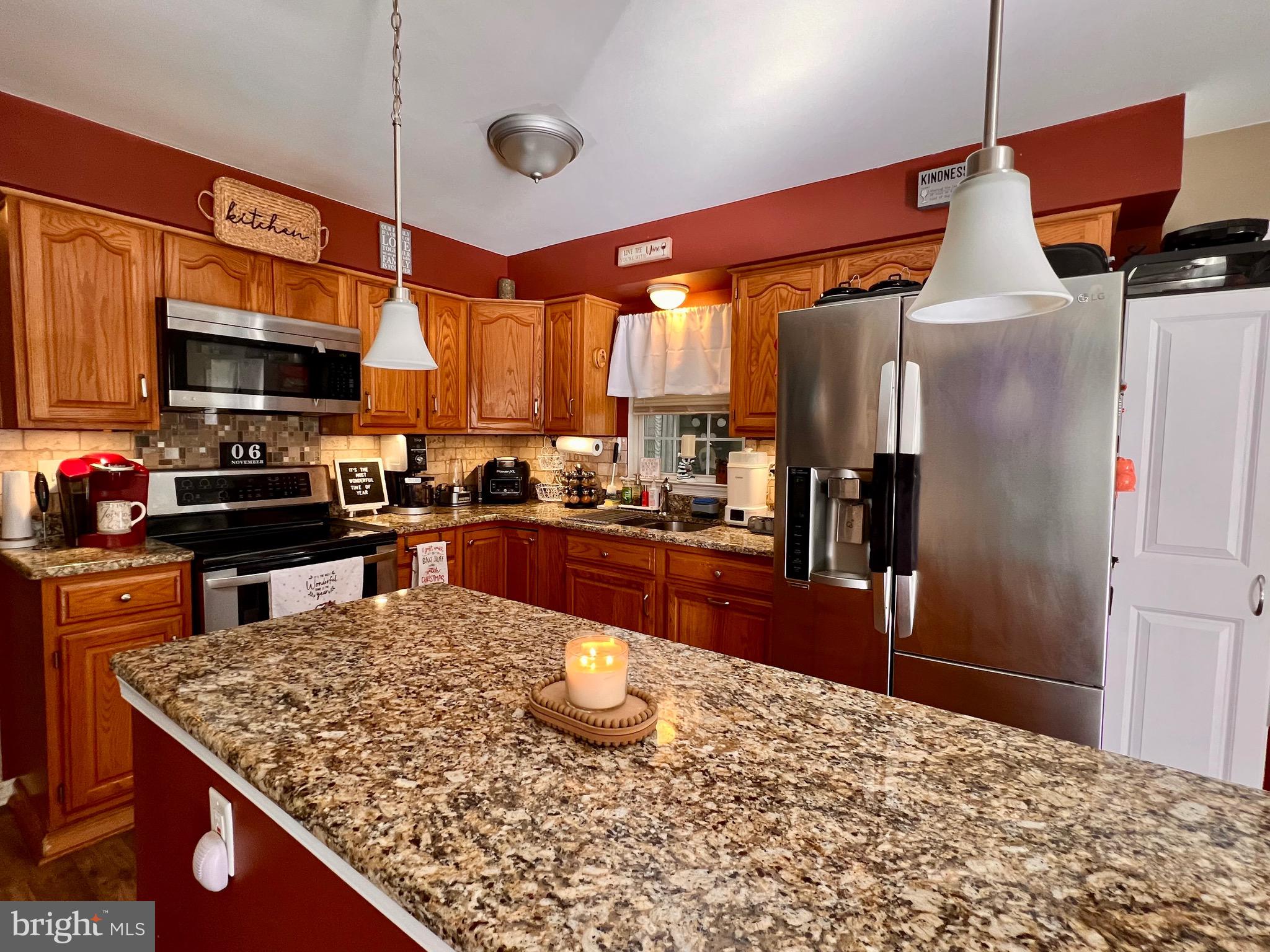 111 Anderson Street Middletown, DE 19709 - Photo 10 of 48 a kitchen with stainless steel appliances kitchen island granite countertop a refrigerator a stove top oven and a sink