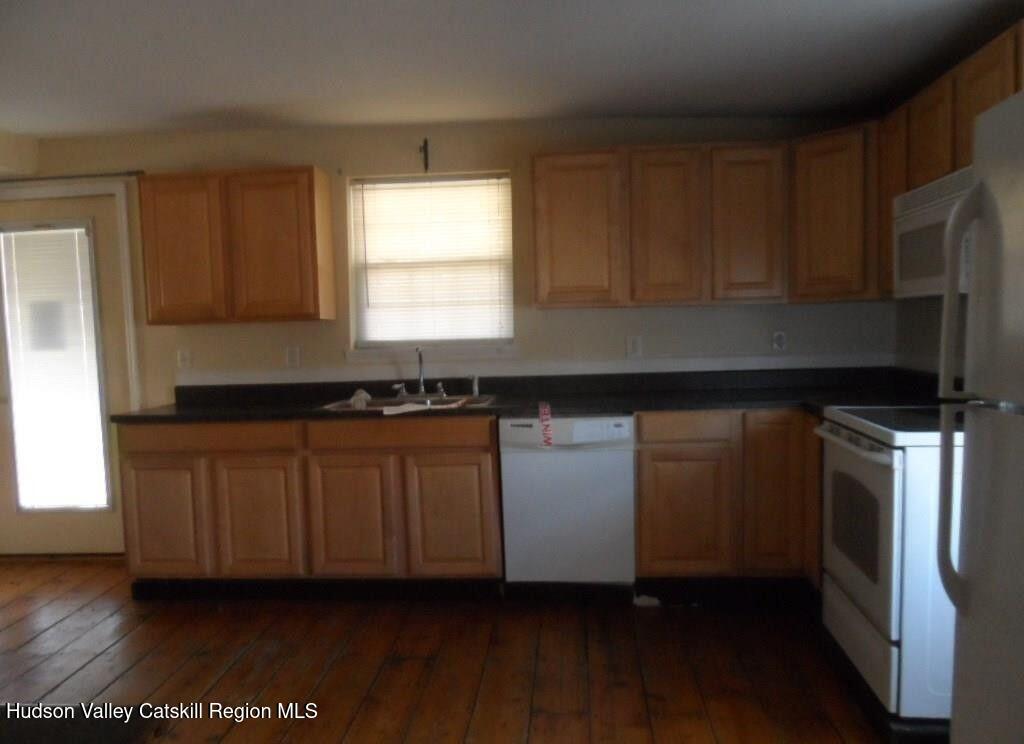 19 Old Post Road Esopus, NY 12493 - Photo 11 of 26 a kitchen with granite countertop a refrigerator a sink and dishwasher with wooden floor