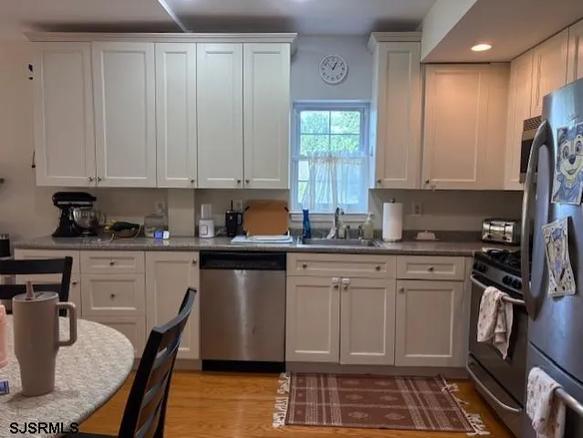 a kitchen with a refrigerator stove and white cabinets