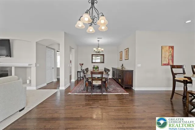 a view of a dining room with furniture a chandelier and wooden floor