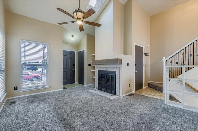 an empty room with windows and fireplace
