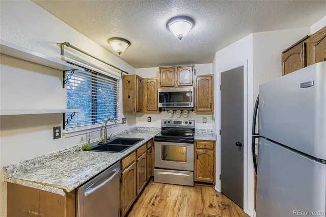 a kitchen with stainless steel appliances granite countertop a refrigerator stove microwave and sink