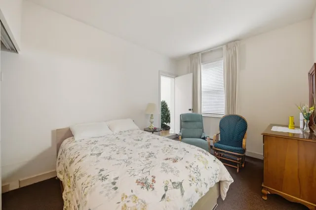 a view of a hallway with wooden floor and furniture