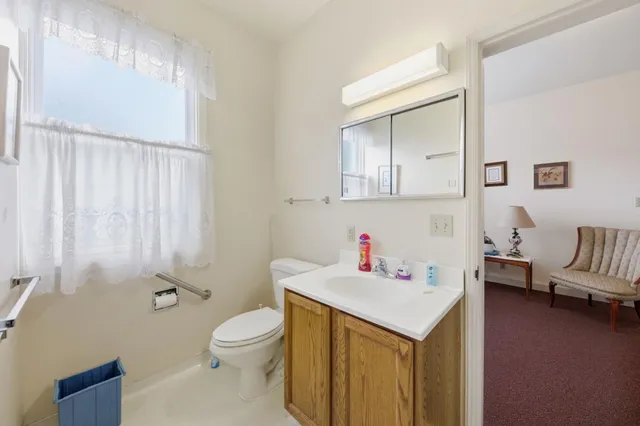 a living room with a table chairs and a refrigerator