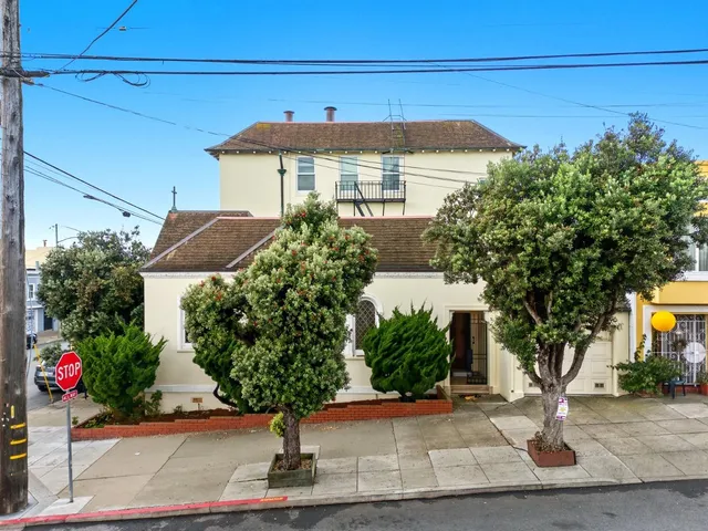 a view of a house with a yard and potted plants