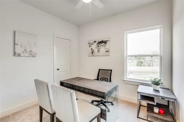 a view of a workspace with furniture and a window
