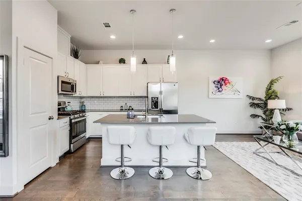 a kitchen with a sink stainless steel appliances and white cabinets