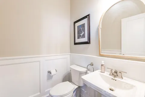 a bathroom with a sink mirror and toilet
