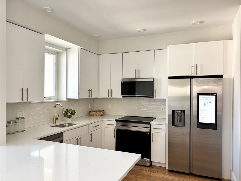 421 High Street, Unit 203 Medford, MA 02155 - Photo 1 of 19 a kitchen with stainless steel appliances a refrigerator sink and microwave