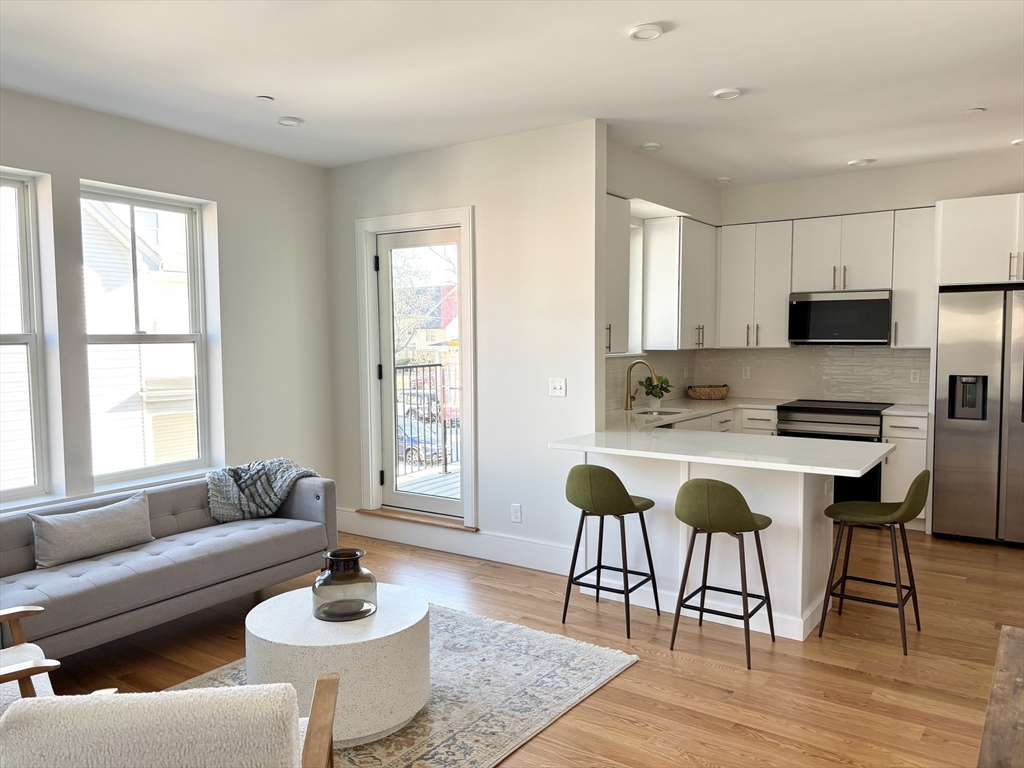 421 High Street, Unit 203 Medford, MA 02155 - Photo 7 of 19 a living room with furniture and a wooden floor