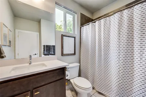 a bathroom with a toilet a sink a mirror and shower curtain