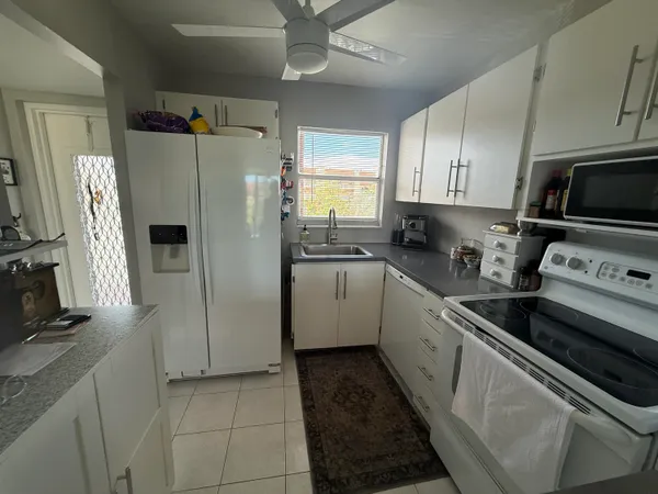 a kitchen with stainless steel appliances a refrigerator sink and microwave