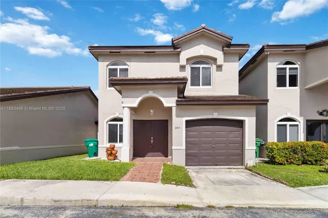 a front view of a house with a yard and garage
