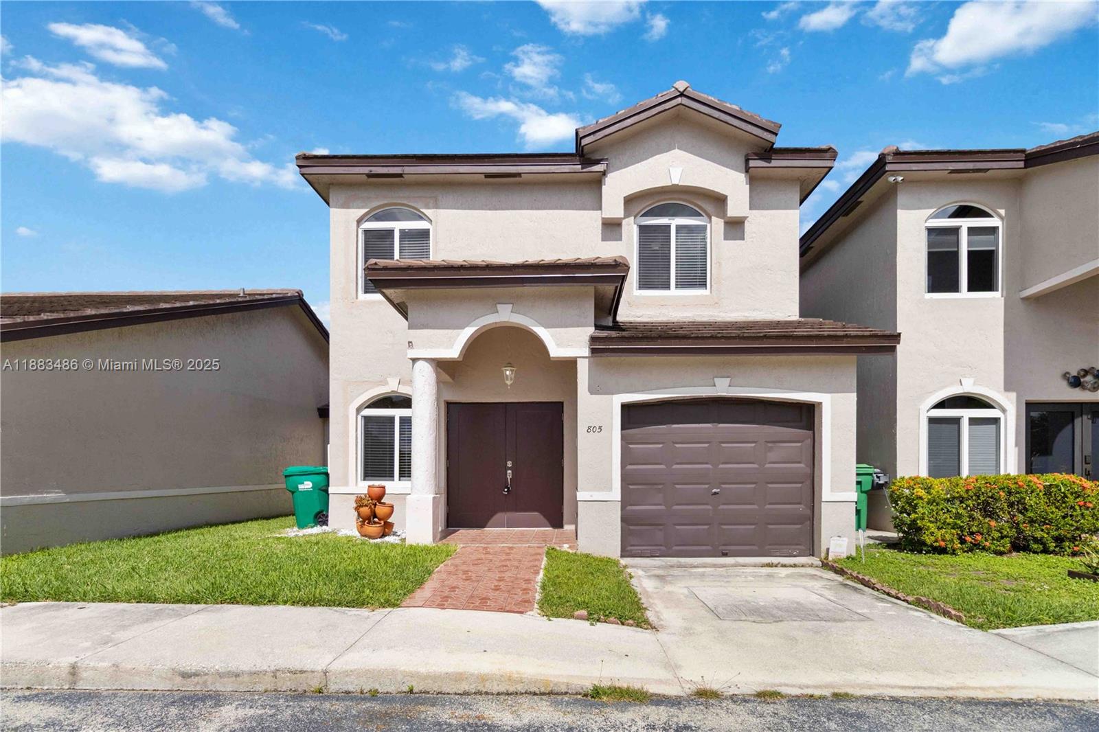 8431 Northwest 188th Terrace, Unit 8058 Hialeah, FL 33015 - Photo 1 of 34 a front view of a house with a yard and garage