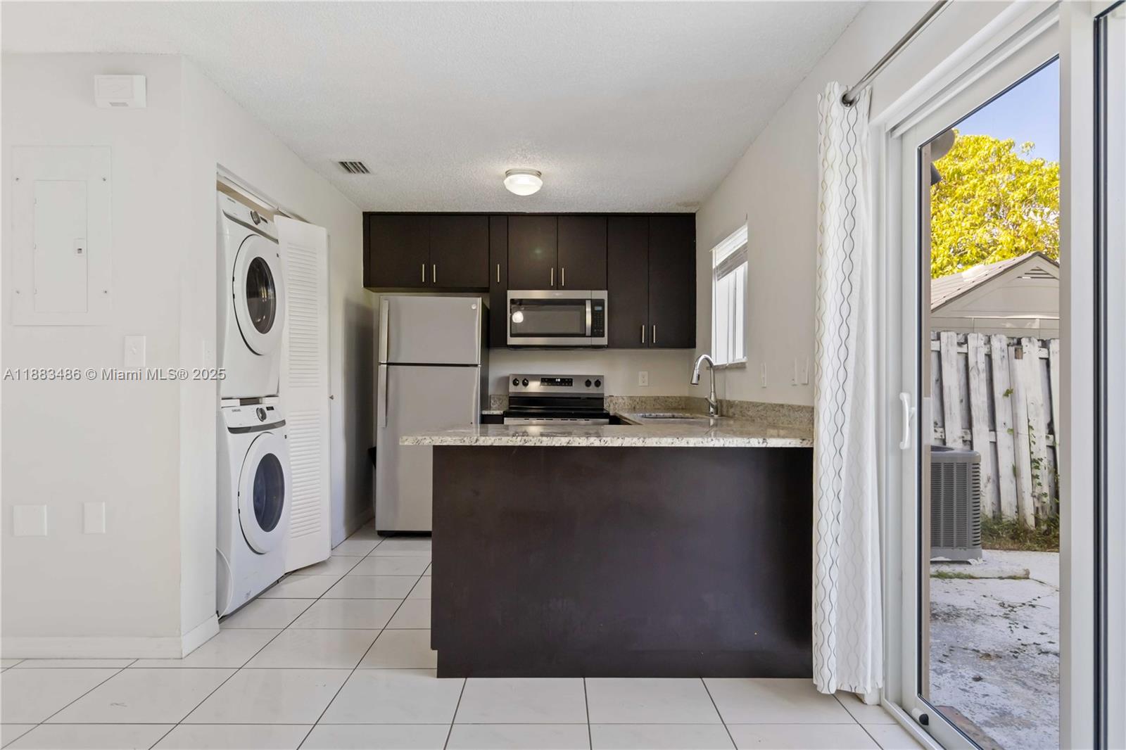 8431 Northwest 188th Terrace, Unit 8058 Hialeah, FL 33015 - Photo 11 of 34 a view of kitchen island with stainless steel appliances granite countertop cabinets and a refrigerator