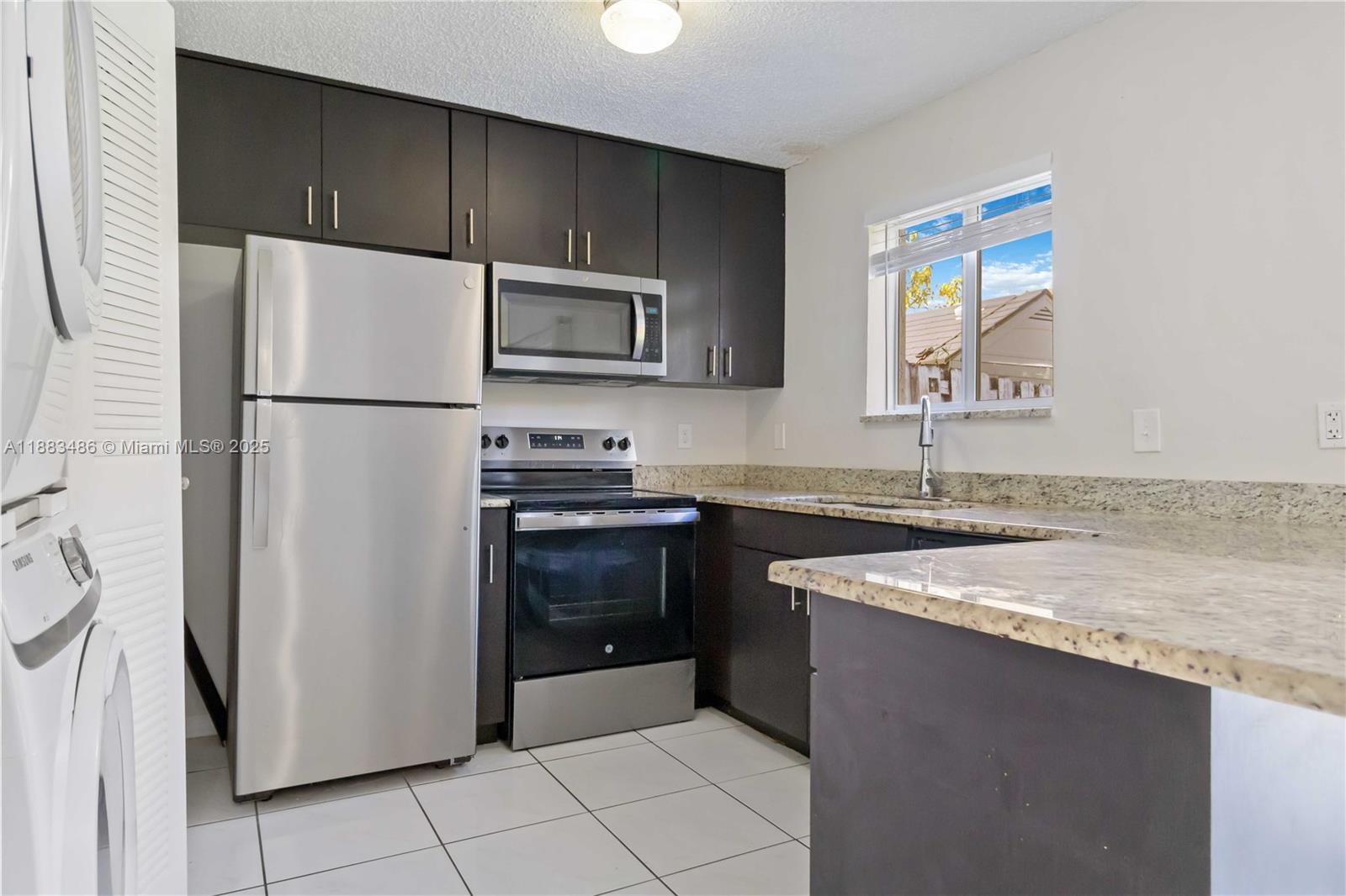 8431 Northwest 188th Terrace, Unit 8058 Hialeah, FL 33015 - Photo 12 of 34 a kitchen with a refrigerator sink and microwave