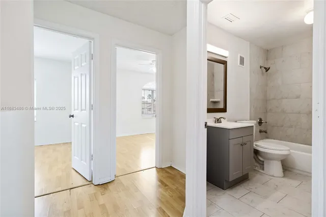 a bathroom with a granite countertop toilet a sink and a mirror