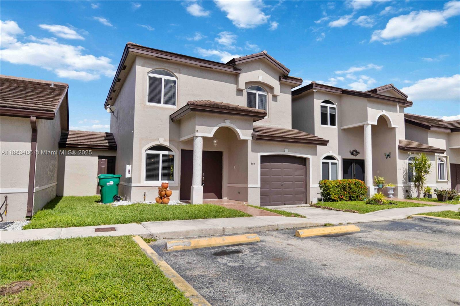 8431 Northwest 188th Terrace, Unit 8058 Hialeah, FL 33015 - Photo 2 of 34 a front view of a house with a yard