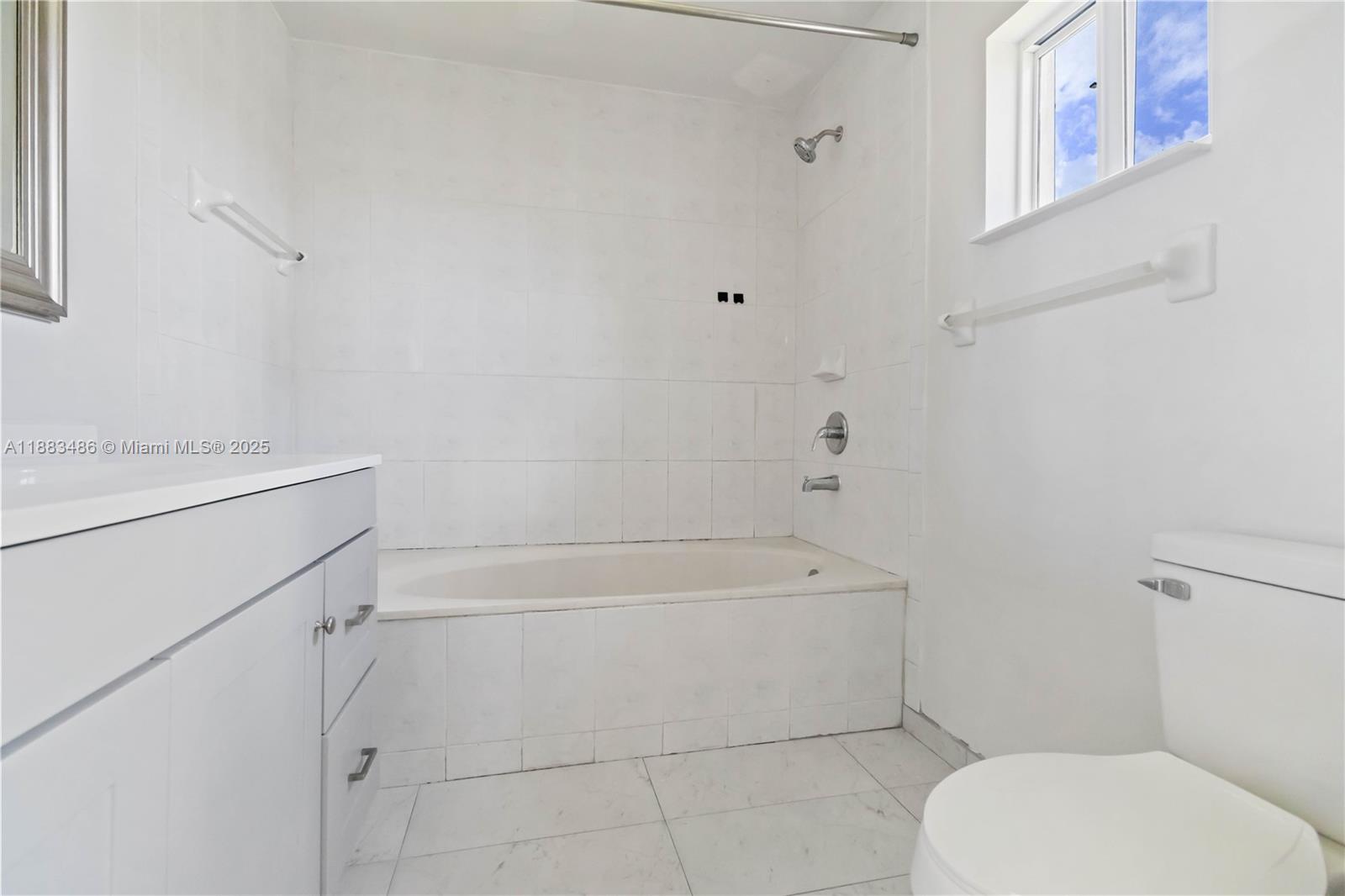 8431 Northwest 188th Terrace, Unit 8058 Hialeah, FL 33015 - Photo 26 of 34 a bathroom with a toilet and a bathtub