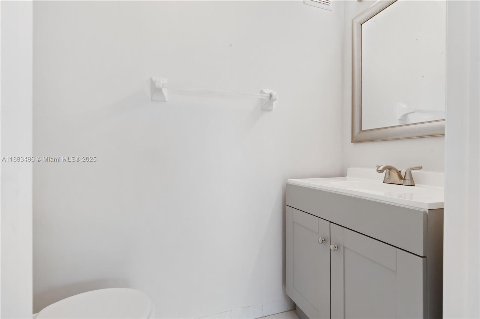 8431 Northwest 188th Terrace, Unit 8058 Hialeah, FL 33015 - Photo 29 of 34 a bathroom with a sink a toilet and mirror