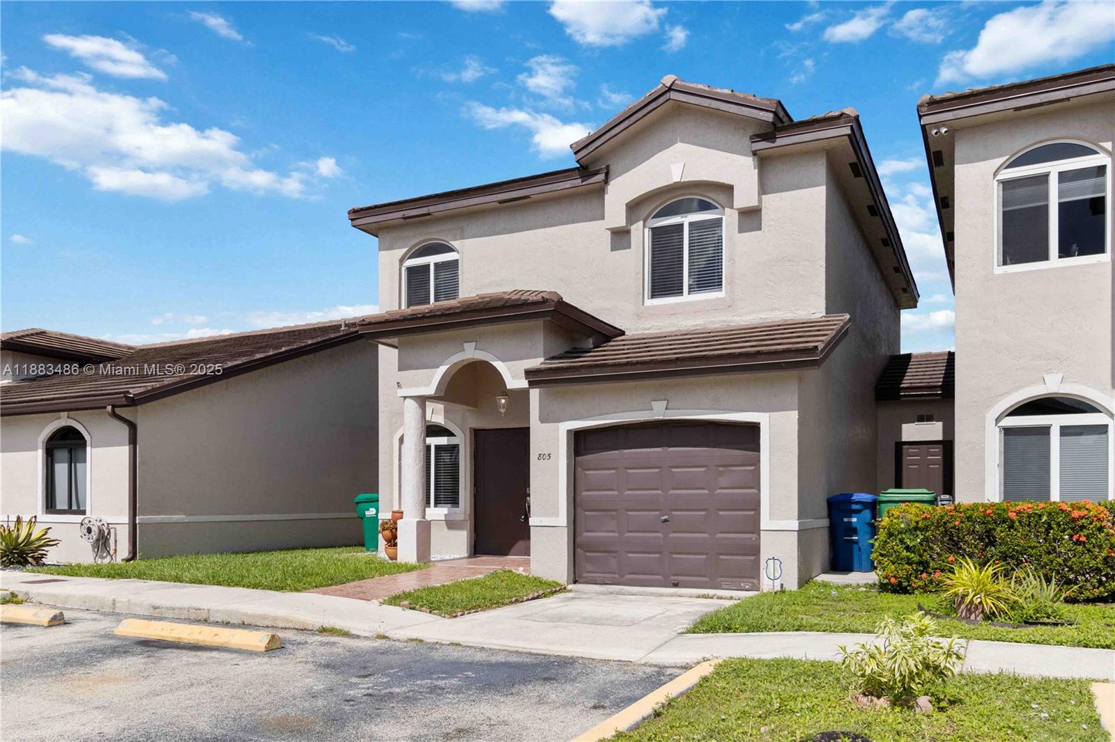 8431 Northwest 188th Terrace, Unit 8058 Hialeah, FL 33015 - Photo 3 of 34 a front view of a house with a yard