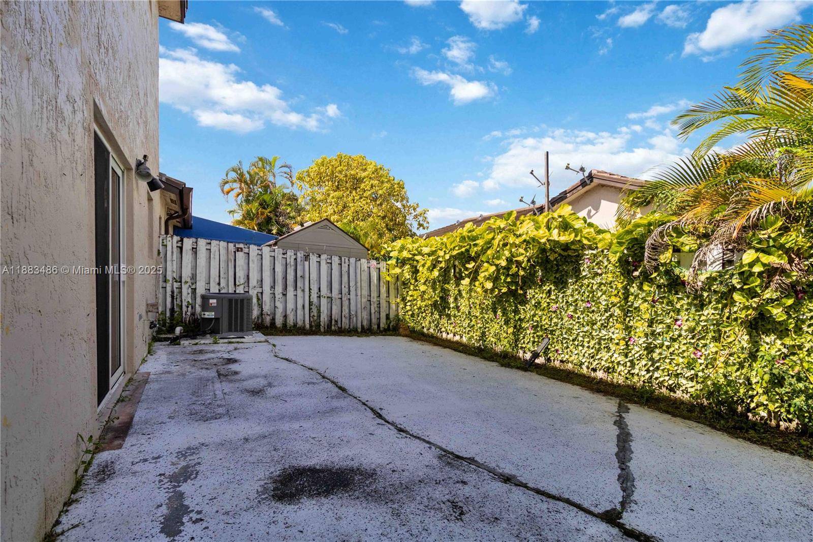 8431 Northwest 188th Terrace, Unit 8058 Hialeah, FL 33015 - Photo 31 of 34 a view of a pathway of a yard with wooden fence