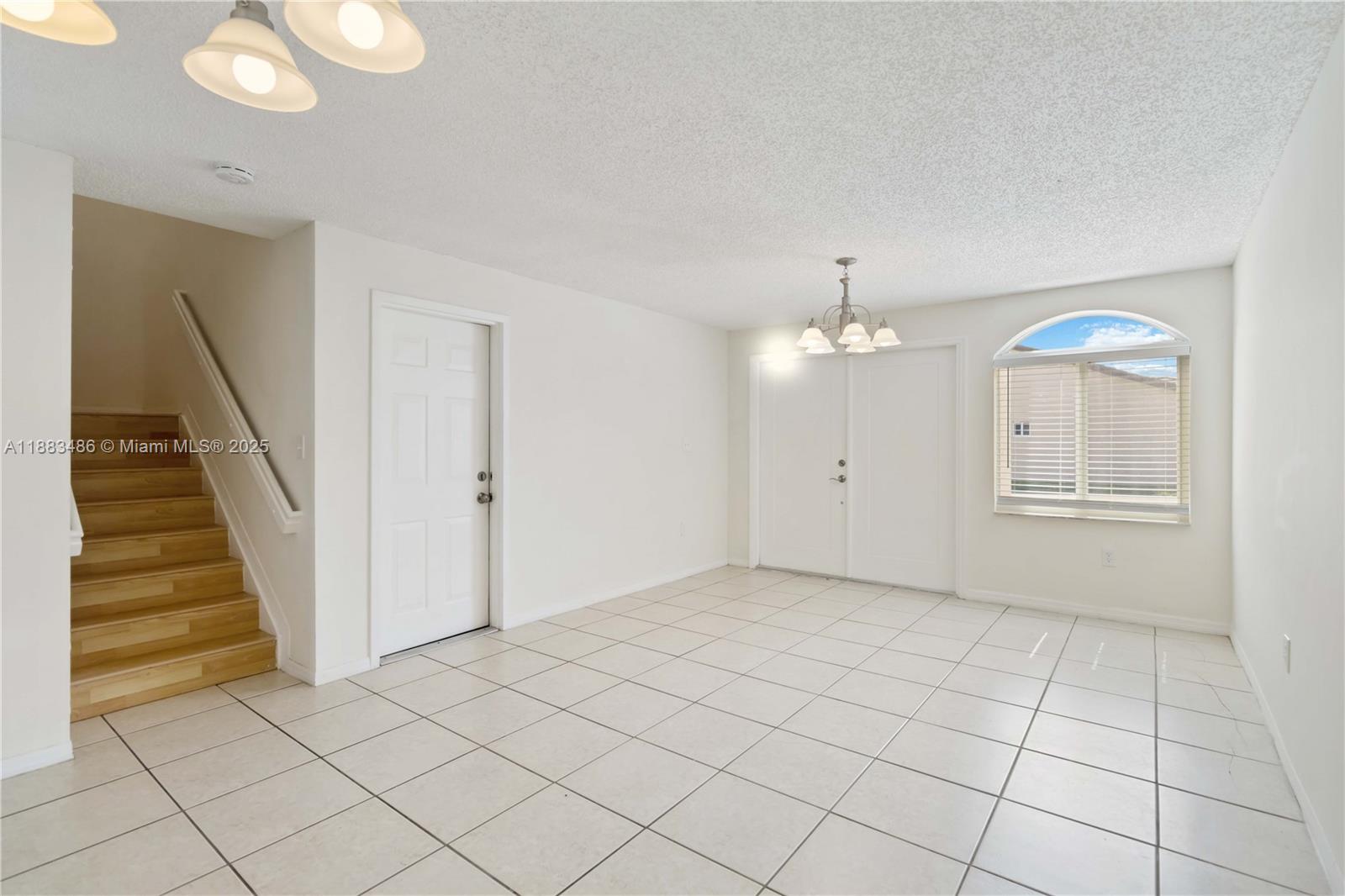 8431 Northwest 188th Terrace, Unit 8058 Hialeah, FL 33015 - Photo 5 of 34 an empty room with white walls and stairs