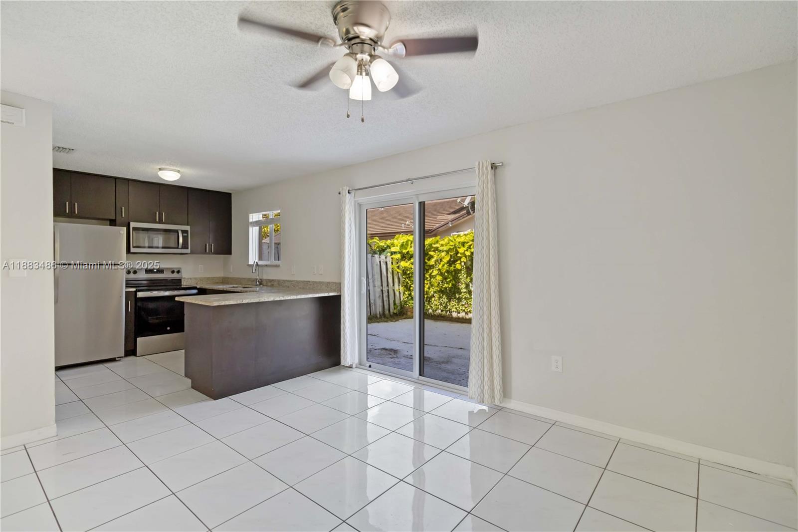 8431 Northwest 188th Terrace, Unit 8058 Hialeah, FL 33015 - Photo 9 of 34 a kitchen with stainless steel appliances a refrigerator and microwave