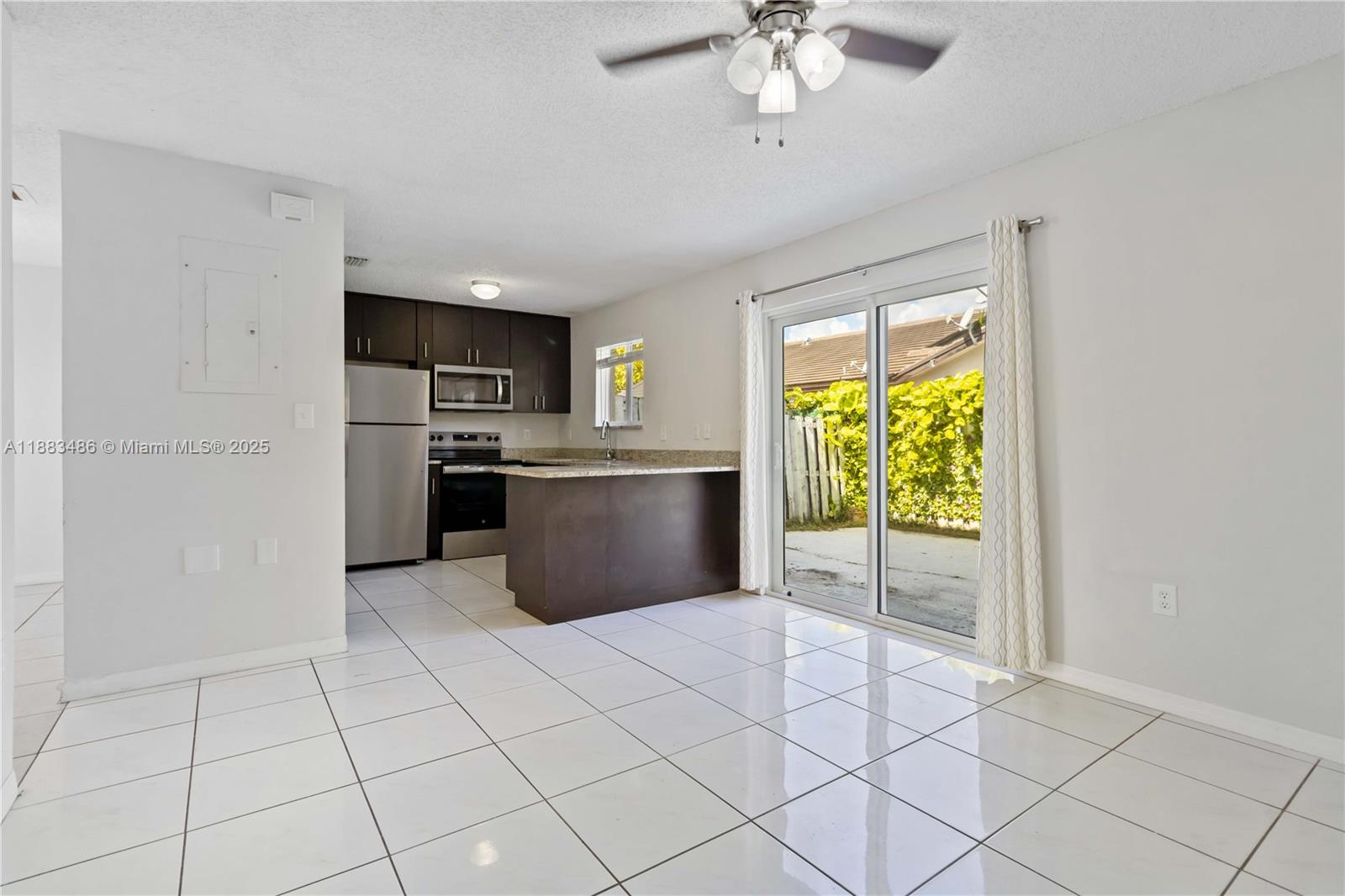8431 Northwest 188th Terrace, Unit 8058 Hialeah, FL 33015 - Photo 10 of 34 a view of a kitchen with microwave and a stove top oven