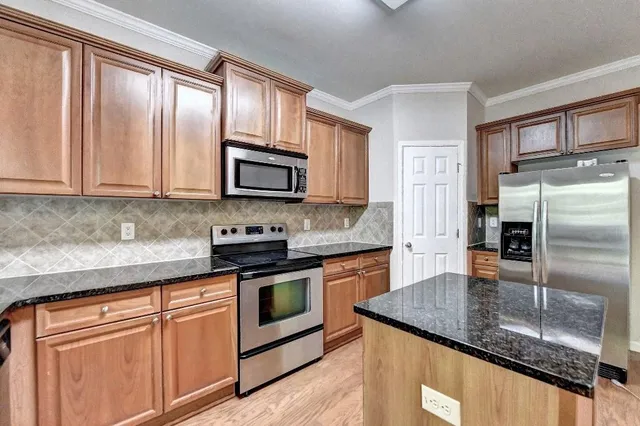 a kitchen with granite countertop cabinets stainless steel appliances and a sink