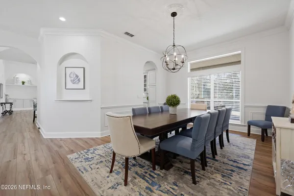 a spacious bedroom with a bed a chandelier and a large window