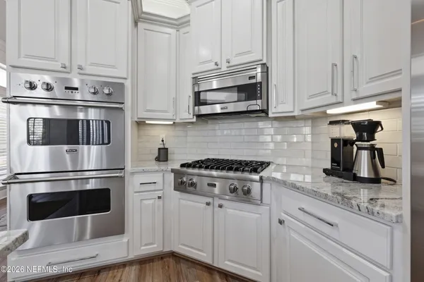 a bathroom with a granite countertop double vanity sink and a mirror