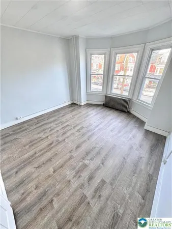 a view of an empty room with closet and a window