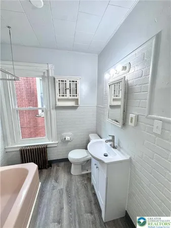 a bathroom with a toilet sink and mirror